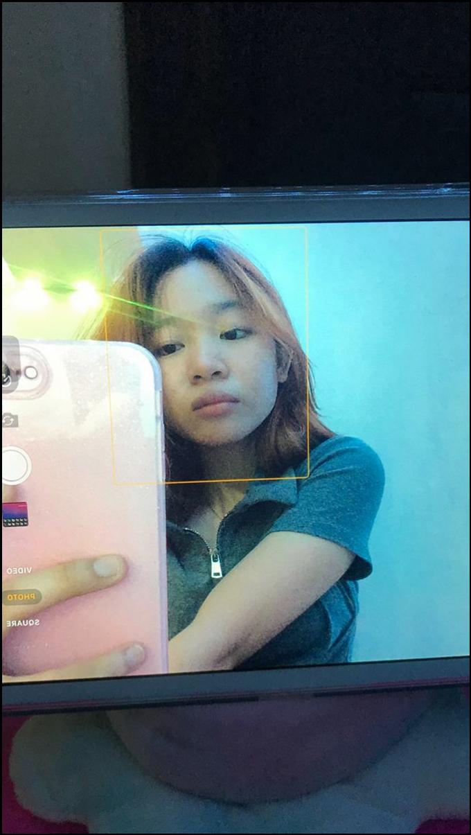 a young girl holding a white and blue t-shirt