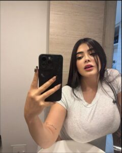 a woman is holding a cell phone in front of her face