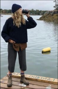 a woman standing on a dock with a camera