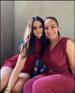 two young women sitting on a wall