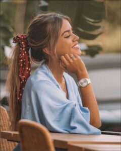 a woman sitting at a table with a cell phone