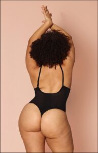 a woman in a black shirt and black shorts is on a black and white striped towel