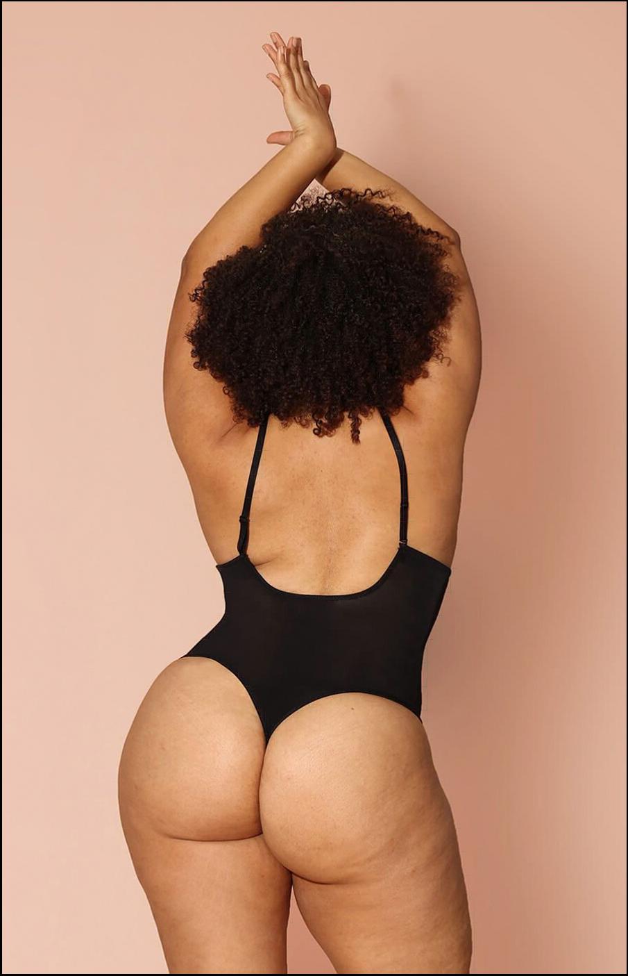 a woman in a black shirt and black shorts is on a black and white striped towel