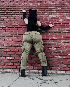 a man is standing on a brick wall with a cell phone