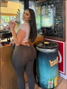 a woman standing next to a wall with a stuffed animal