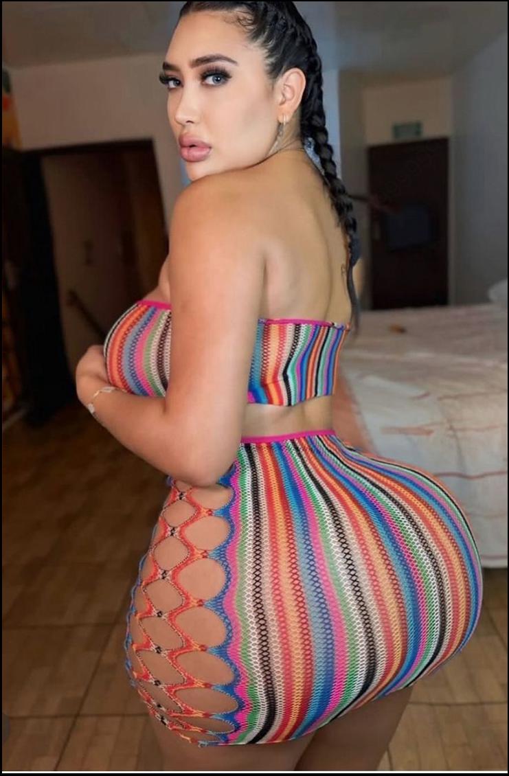 a woman in a pink dress is holding a purple flower