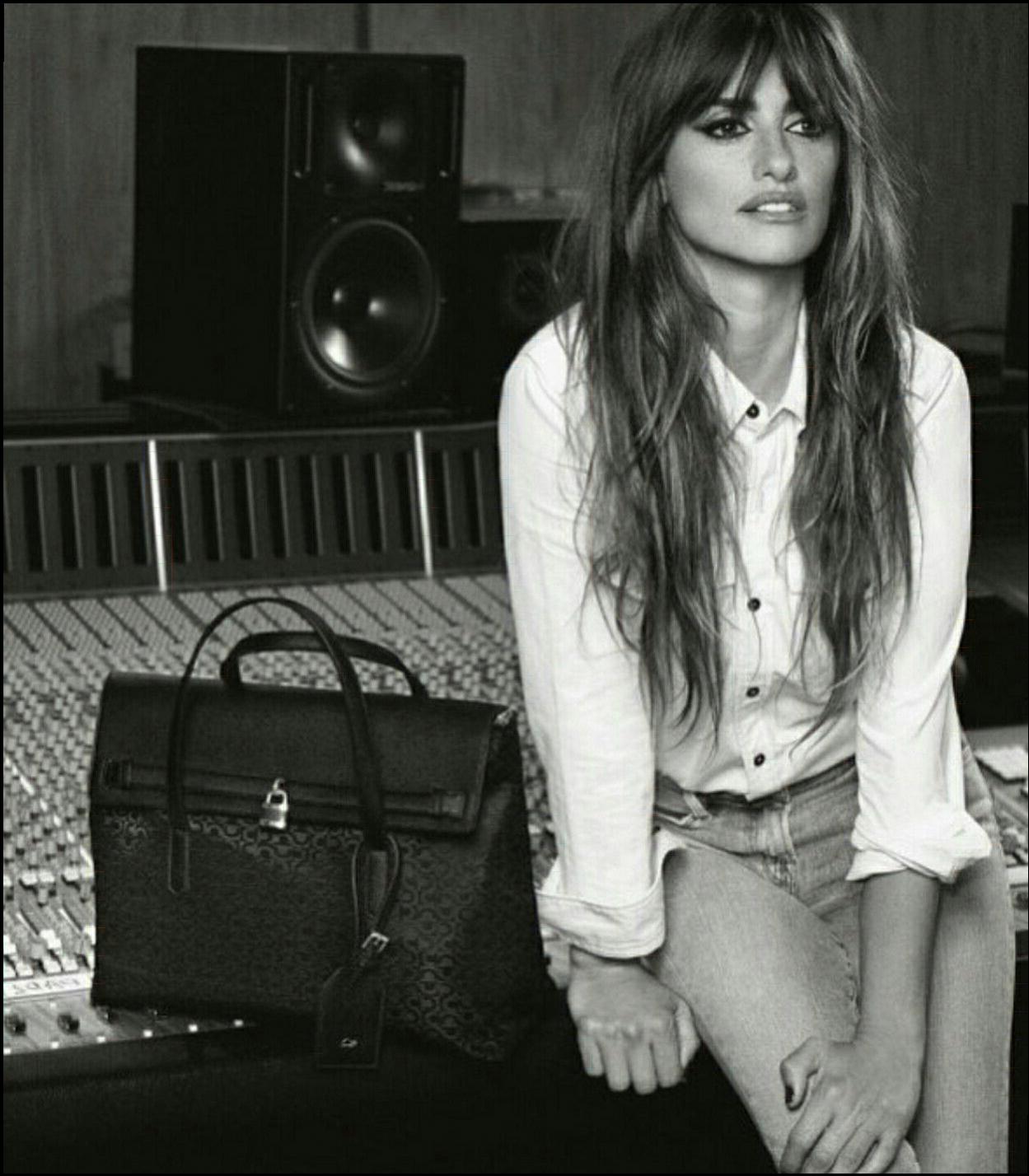 a woman sitting on a bed with a suitcase