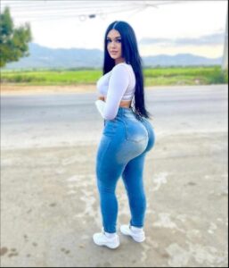 a woman is standing on a sidewalk with a blue umbrella