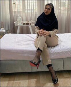 a woman sitting on a bed with a white bedspread