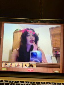 a woman is sitting on a tv and looking at a cell phone