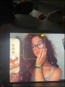 a woman is holding a cell phone in front of a picture