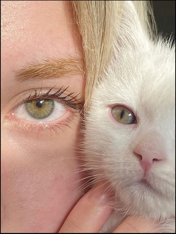 a woman is smiling and petting a cat