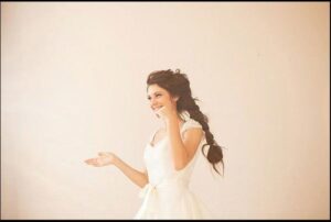 a woman is standing in a room with a white wall