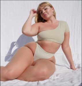 a woman in a bikini sitting on a bed