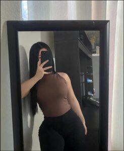 a woman is standing in front of a mirror