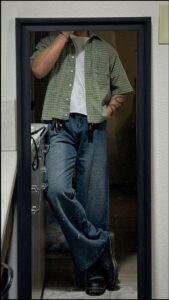 a man is wearing a tie and is standing in a doorway