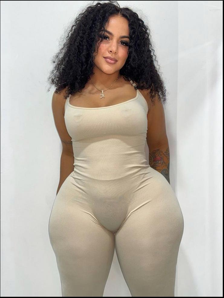 a woman in a black shirt and white pants posing for a picture