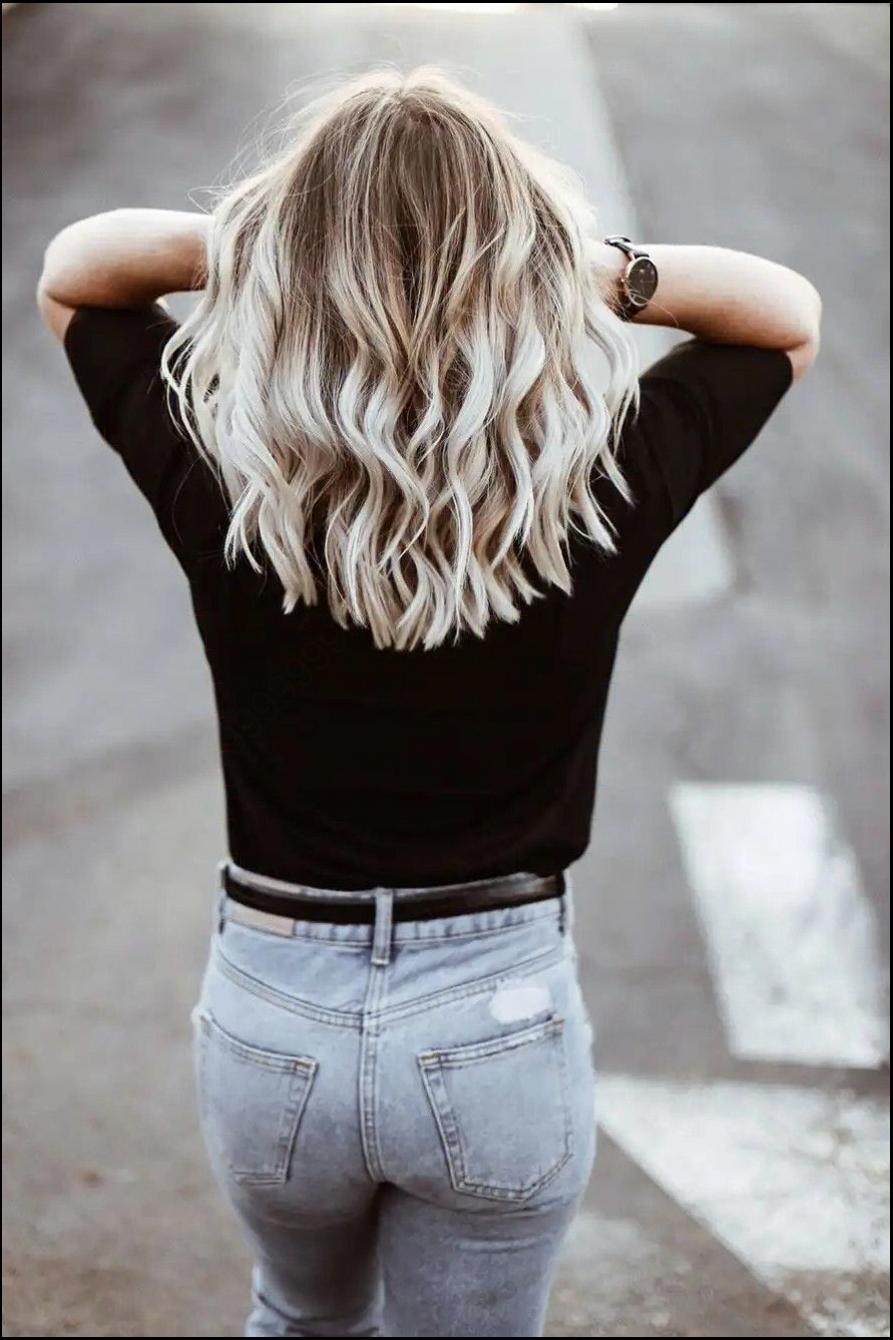 a woman is standing on a sidewalk with a black and white striped shirt