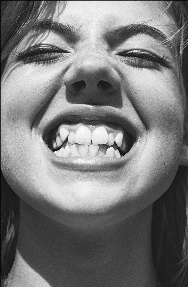 a woman with a black and white face is looking at the camera