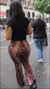 a woman in a black dress is holding a stuffed animal