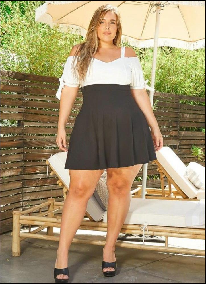 a woman in a black dress standing on a bench