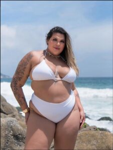 a woman in a bikini standing on a beach