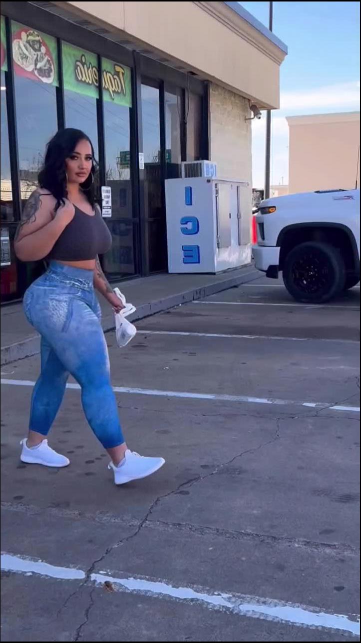 a woman is standing on a sidewalk holding a cell phone