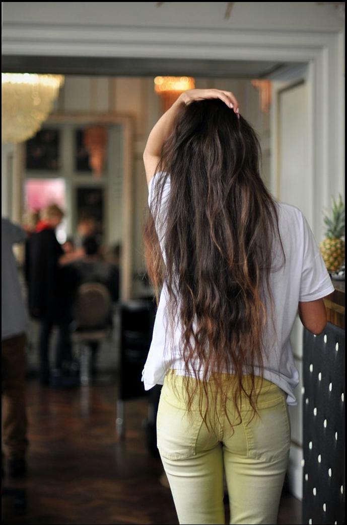 a woman is standing in a room with a white wall