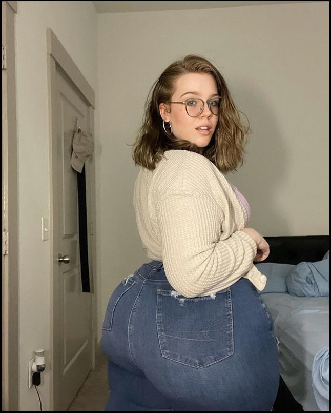 a woman sitting on a bed with a white shirt