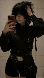 a woman in a black shirt and black pants holding a cell phone