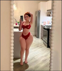 a woman in a red dress is in a kitchen