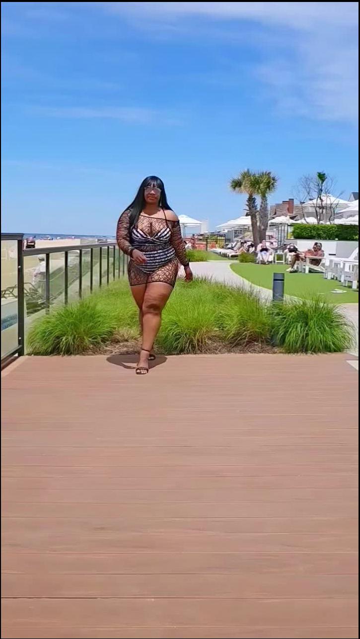 a woman is standing on a sidewalk with a skateboard