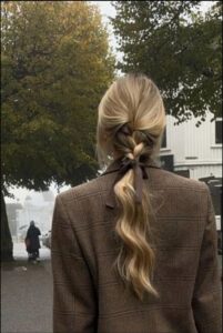 a woman in a suit and tie standing in the street
