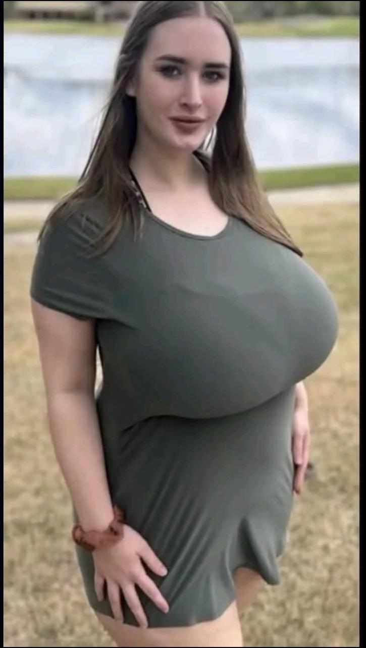 a woman is standing in the grass with a frisbee