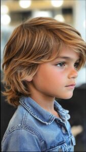 a young boy is smiling and wearing a blue shirt