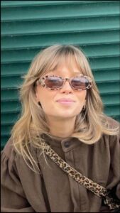 a woman wearing glasses and a black hat