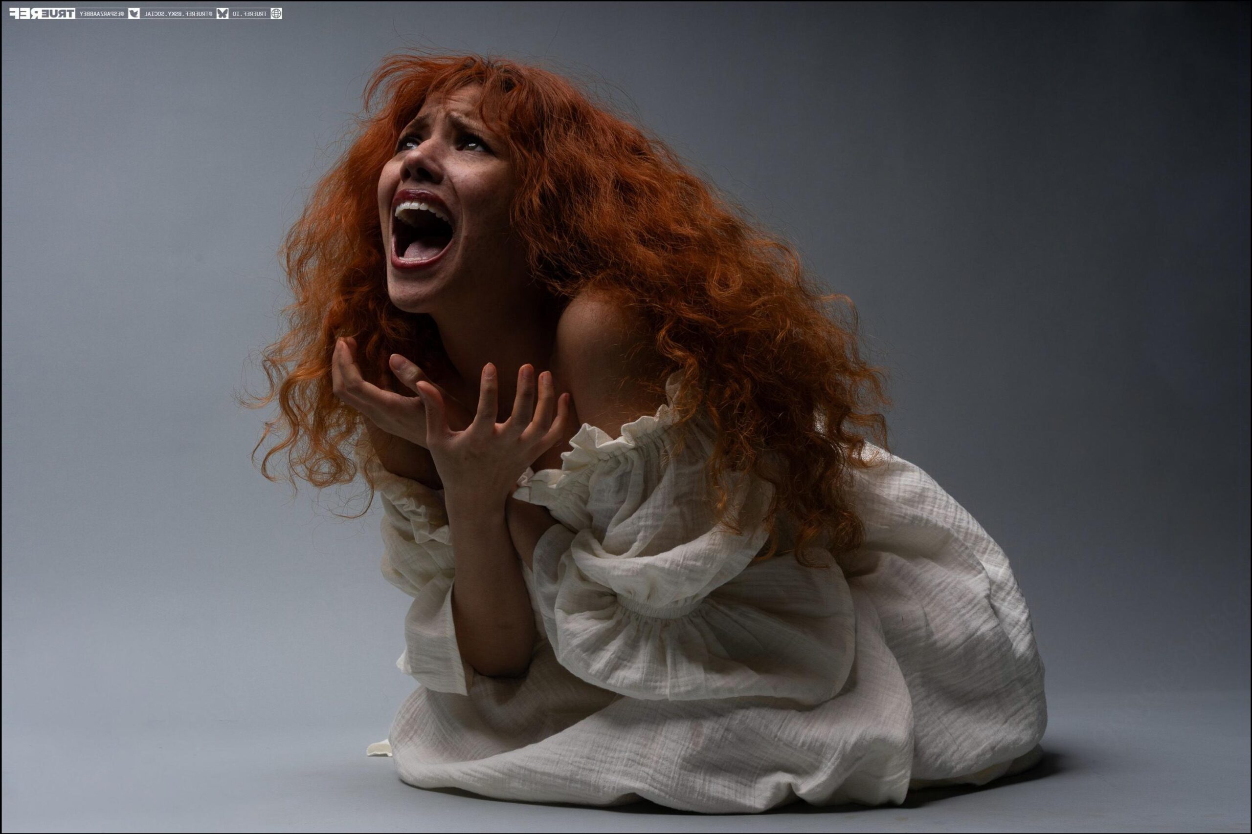 a woman is laying down on a white sheet