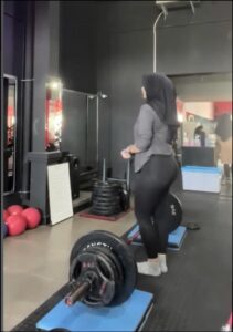 a woman is standing on a black and white tiled floor
