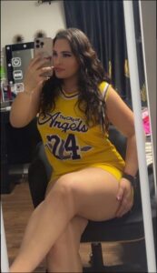 a woman sitting on a chair and looking at a cell phone