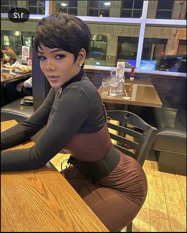 a woman is posing for a picture on a wooden table