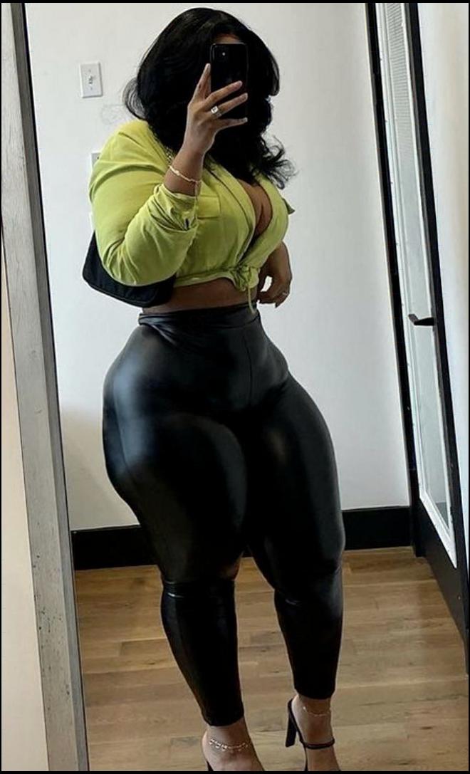 a woman sitting on a wooden floor with a black and white striped shirt