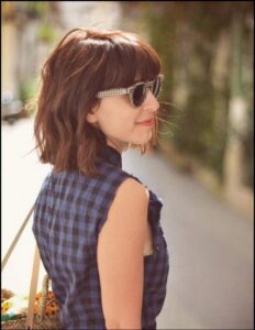 a woman is standing in the street with a blue umbrella