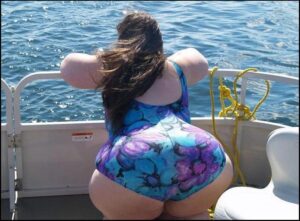 a woman in a bikini sitting on a boat