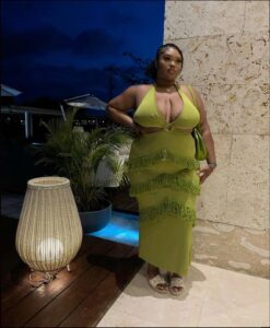 a woman in a pink dress and a green and white tank top