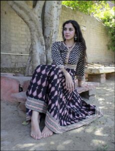 a woman sitting on a bench with a flower in her hand