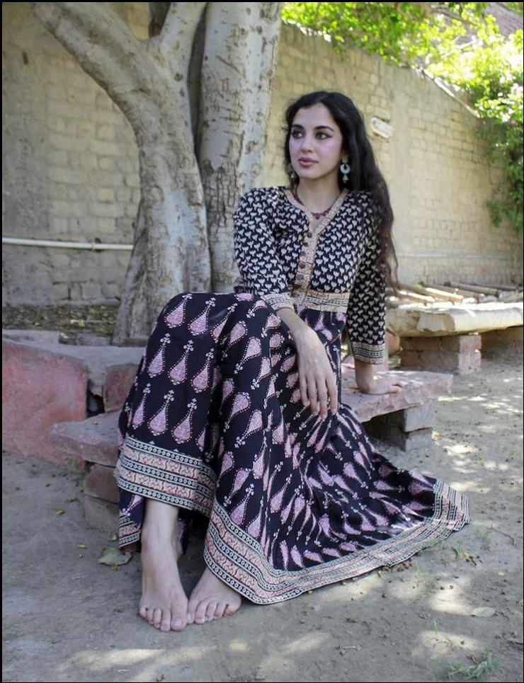 a woman sitting on a bench with a flower in her hand