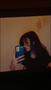 a woman is sitting on a wall looking at her cell phone