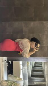 a man is standing in front of a wall with a red umbrella