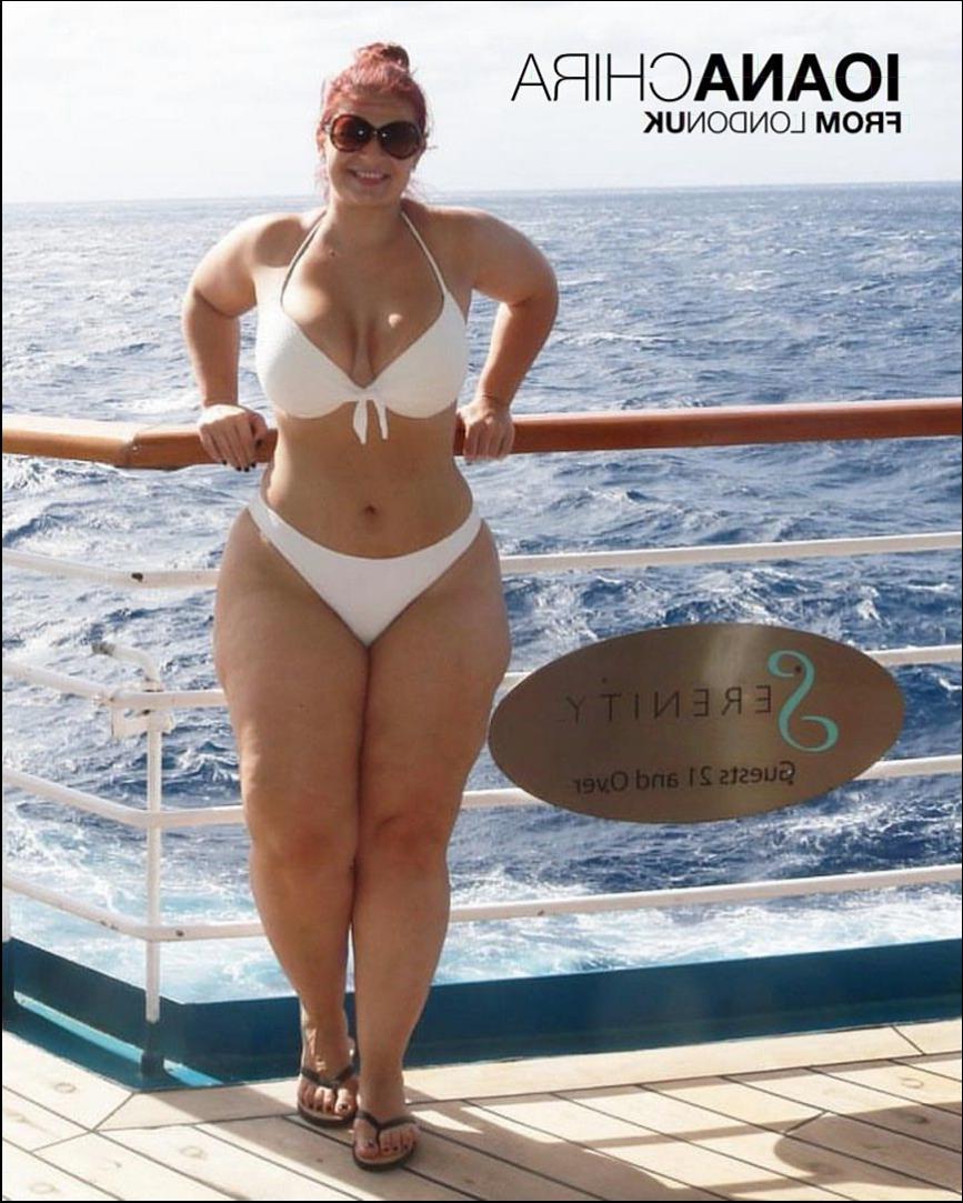 a woman standing on a pier holding a surfboard
