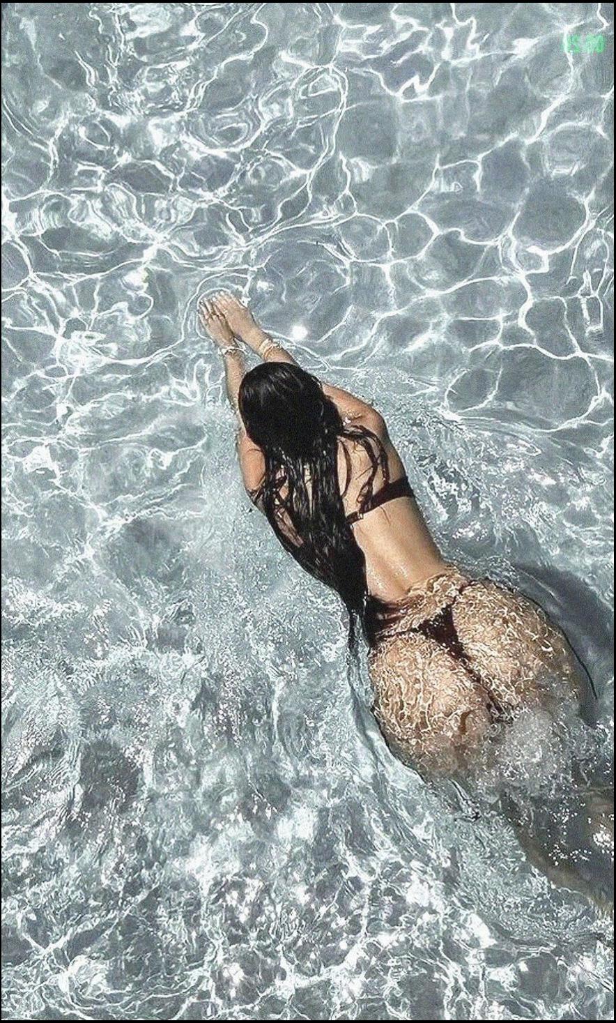a woman is laying on the beach with a surfboard